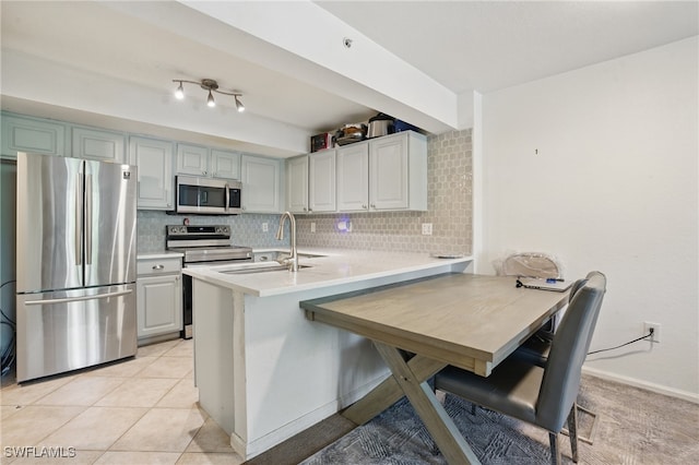 4109 Residence Dr Unit 515, Fort Myers, FL 33901 - kitchen with appliances with stainless steel finishes, a sink, backsplash, a peninsula, and light countertops
