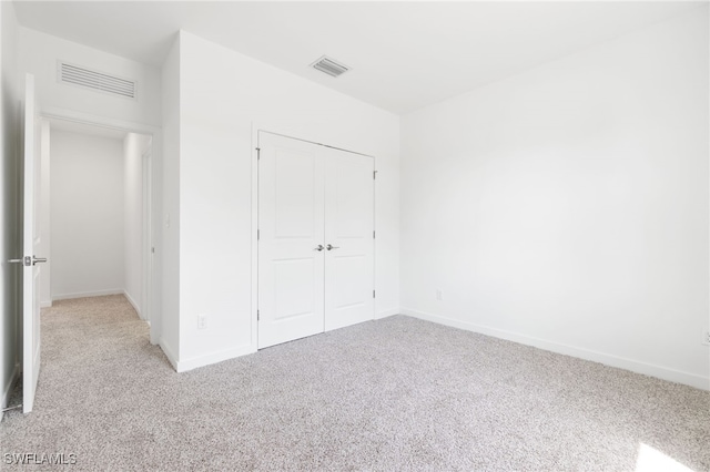 713 Wells Ave, Lehigh Acres, FL 33972 - unfurnished bedroom featuring light carpet, a closet, baseboards, and visible vents