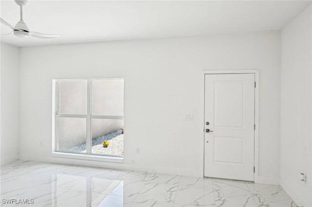 empty room with light marble finish flooring, ceiling fan, and baseboards