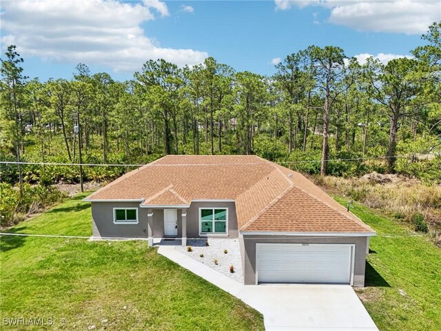 view of front of property featuring a garage, stucco siding, and a front yard
