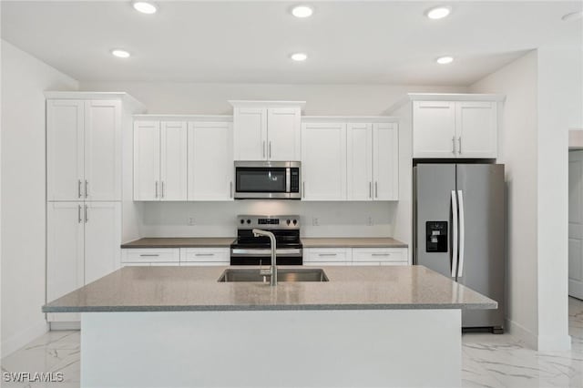 kitchen with appliances with stainless steel finishes, light marble finish floors, baseboards, white cabinetry, and recessed lighting
