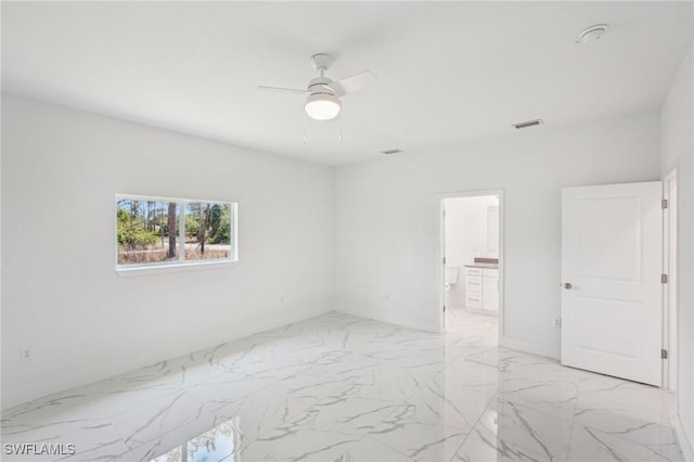 empty room with ceiling fan and light marble finish floors