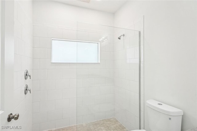 full bathroom with toilet and a tile shower