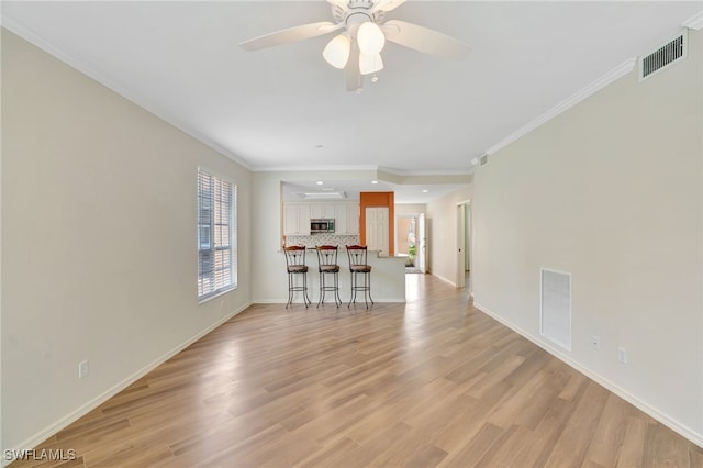 unfurnished living room featuring crown molding, baseboards, light wood-style flooring, ceiling fan, and recessed lighting