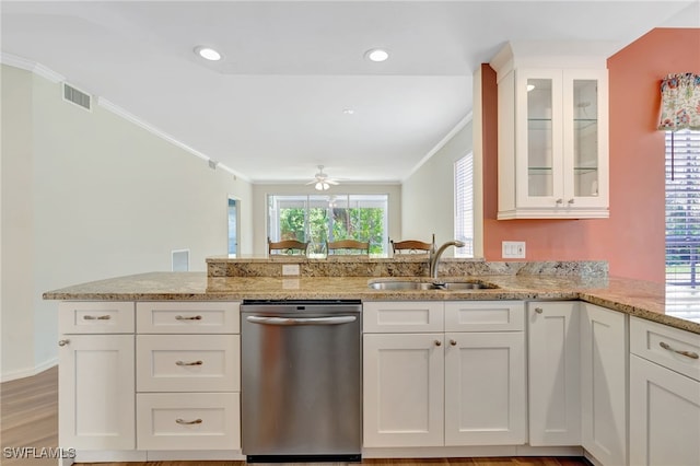 kitchen with stainless steel dishwasher, a sink, ornamental molding, a peninsula, and white cabinets