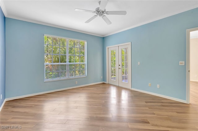 empty room featuring french doors, ornamental molding, wood finished floors, and baseboards