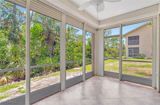 unfurnished sunroom with ceiling fan