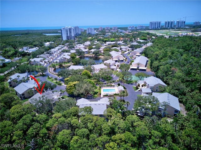 aerial view of property and surrounding area with a large body of water and nearby urban area