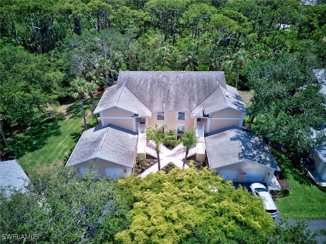 aerial view of property and surrounding area with a heavily wooded area