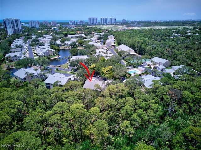 view of property location with nearby urban area, a forest, and nearby suburban area