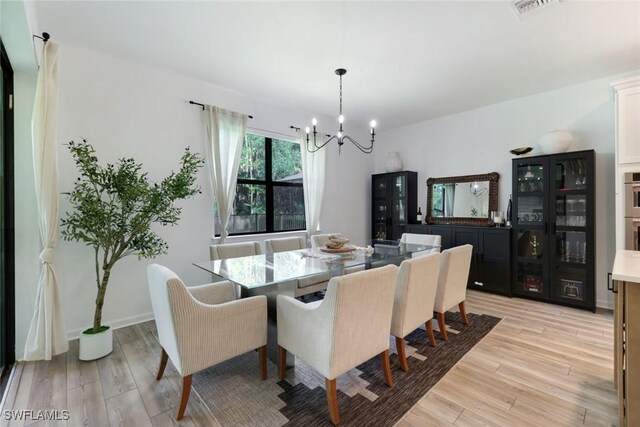 10427 Ventana Ln, Naples, FL 34120 - dining area with a chandelier and light wood-type flooring