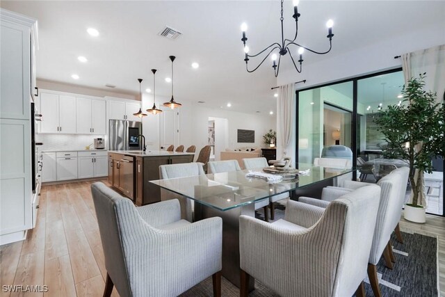 10427 Ventana Ln, Naples, FL 34120 - dining area featuring a chandelier, light wood-style floors, and recessed lighting