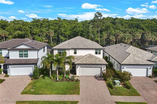 10427 Ventana Ln, Naples, FL 34120 - traditional home with driveway, a wooded view, and a front yard