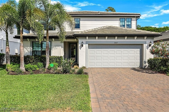 10427 Ventana Ln, Naples, FL 34120 - view of front of home featuring decorative driveway, a garage, stucco siding, and a front yard
