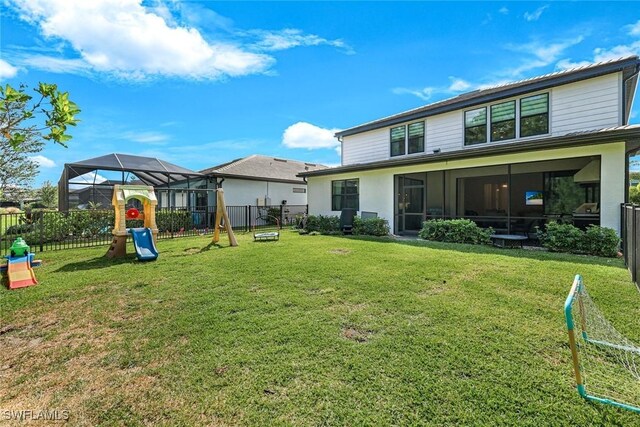 10427 Ventana Ln, Naples, FL 34120 - rear view of house with a playground