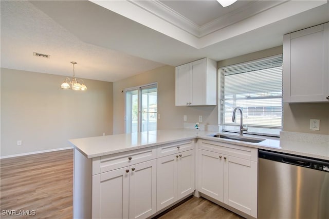 kitchen featuring stainless steel dishwasher, a sink, crown molding, a peninsula, and light countertops