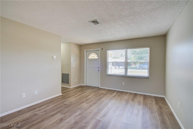 entrance foyer with wood finished floors, a textured ceiling, and baseboards