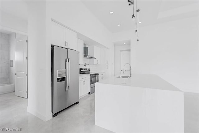 305 Diplomat Pkwy E, Cape Coral, FL 33909 - kitchen featuring stainless steel appliances, a sink, white cabinets, wall chimney range hood, and recessed lighting