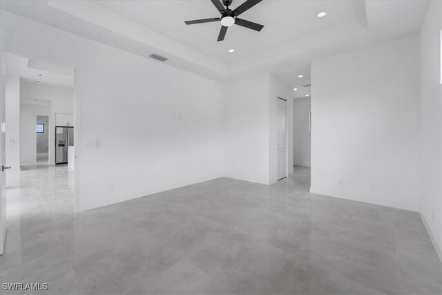 305 Diplomat Pkwy E, Cape Coral, FL 33909 - spare room featuring ceiling fan, a raised ceiling, concrete flooring, and recessed lighting