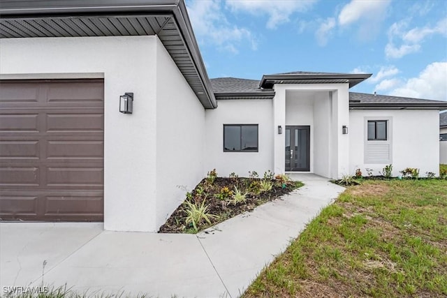 305 Diplomat Pkwy E, Cape Coral, FL 33909 - property entrance featuring stucco siding, a garage, and roof with shingles