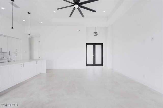 305 Diplomat Pkwy E, Cape Coral, FL 33909 - unfurnished living room with a towering ceiling, a ceiling fan, french doors, a tray ceiling, and recessed lighting