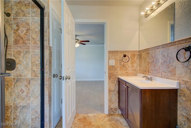 bathroom with a shower stall, vanity, ceiling fan, ornamental molding, and tile patterned flooring