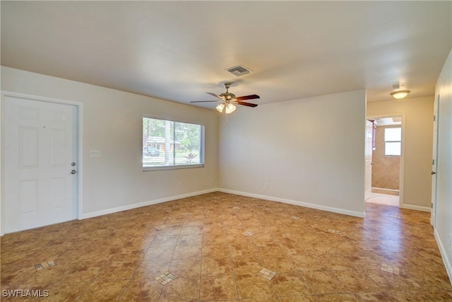 spare room with plenty of natural light, a ceiling fan, baseboards, and light tile patterned flooring