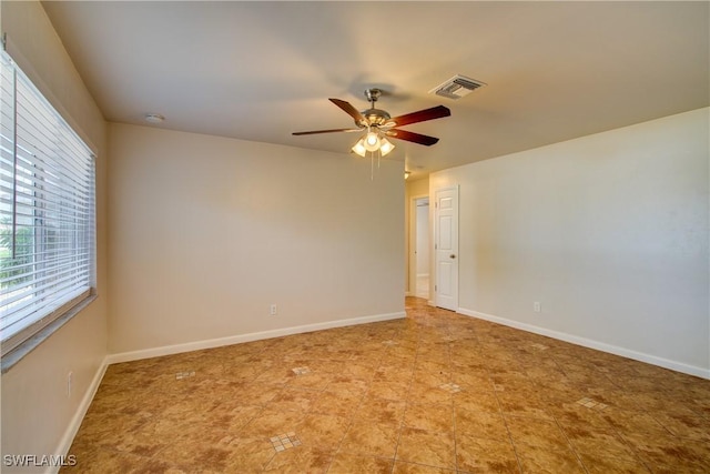 spare room featuring ceiling fan, baseboards, a smoke detector, and light tile patterned floors
