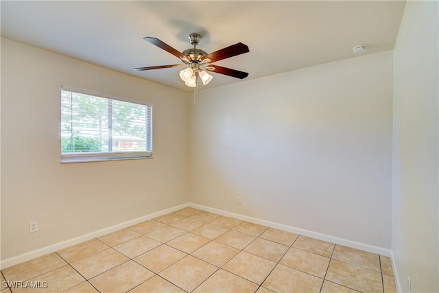 spare room with a smoke detector, ceiling fan, light tile patterned flooring, and baseboards