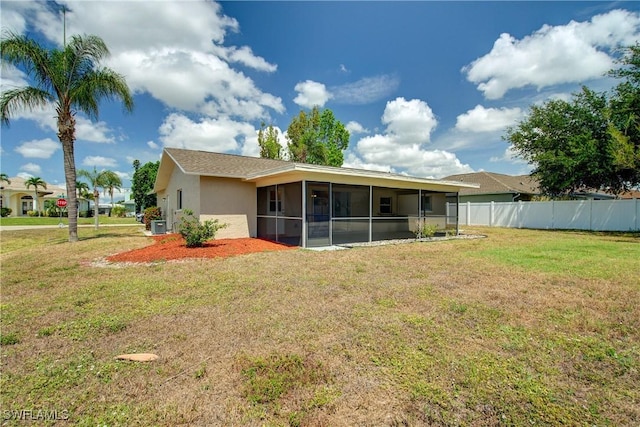 rear view of house featuring a sunroom and stucco siding