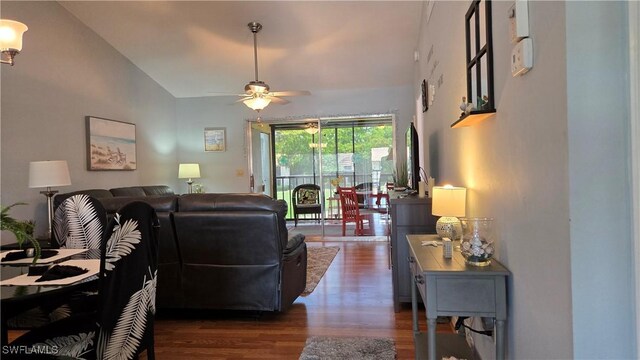 living area featuring dark wood-style floors, ceiling fan, and lofted ceiling