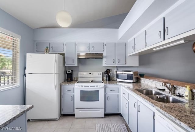 kitchen with white appliances, a sink, under cabinet range hood, light tile patterned floors, and light stone countertops
