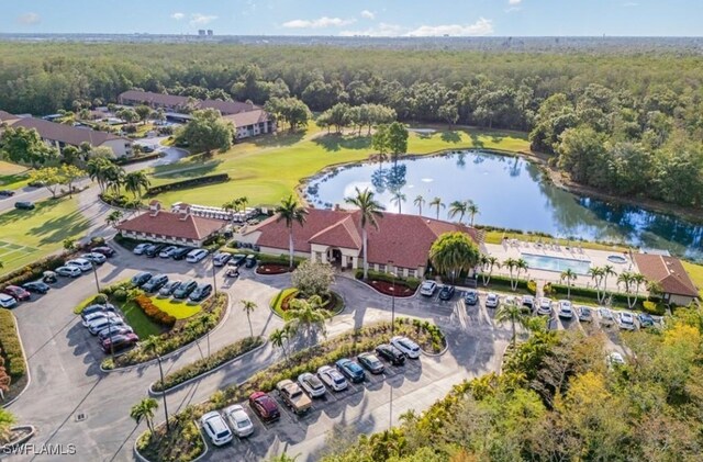 drone / aerial view of a forest, a large body of water, and a local golf course