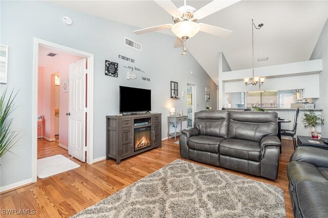 13090 Cross Creek Ct Unit 210, Fort Myers, FL 33912 - living room with a chandelier, light wood-style flooring, ceiling fan, and high vaulted ceiling