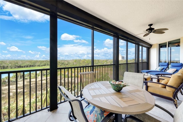 sunroom / solarium with a ceiling fan, tile patterned flooring, and a textured ceiling