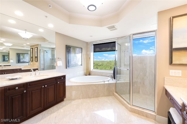 bathroom featuring a shower stall, a raised ceiling, a garden tub, vanity, and recessed lighting