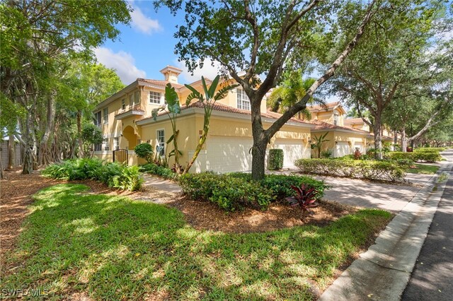 20290 Burnside Pl Unit 1102, Estero, FL 33928 - view of home's exterior featuring a garage, stucco siding, a chimney, and driveway