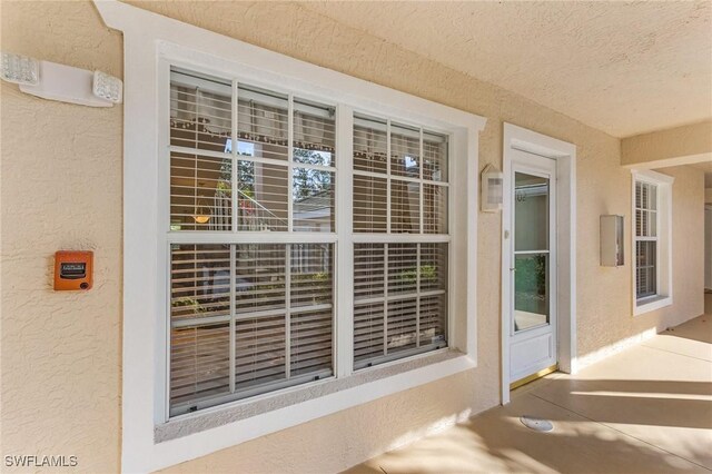 doorway to property with stucco siding and a porch