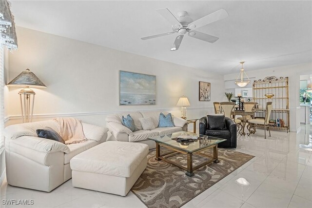 living room with a ceiling fan and light marble finish floors