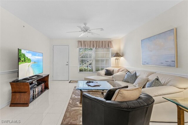 living room featuring ceiling fan, light tile patterned flooring, and baseboards