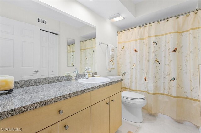 bathroom with toilet, tile patterned floors, and vanity