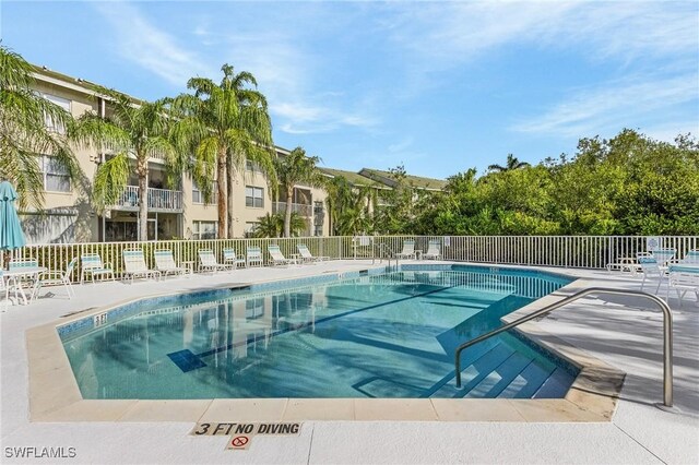 community pool with fence and a patio