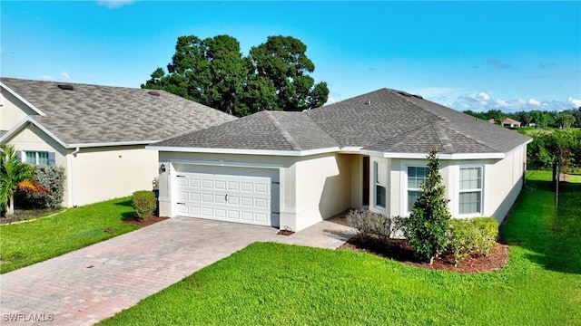 ranch-style home featuring an attached garage, stucco siding, decorative driveway, a front lawn, and roof with shingles