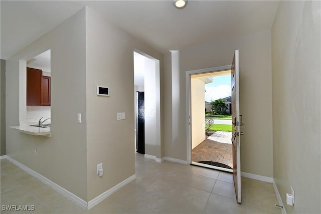 entryway with baseboards and light tile patterned flooring