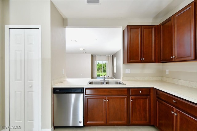 kitchen featuring dishwasher, a sink, light countertops, and reddish brown cabinets