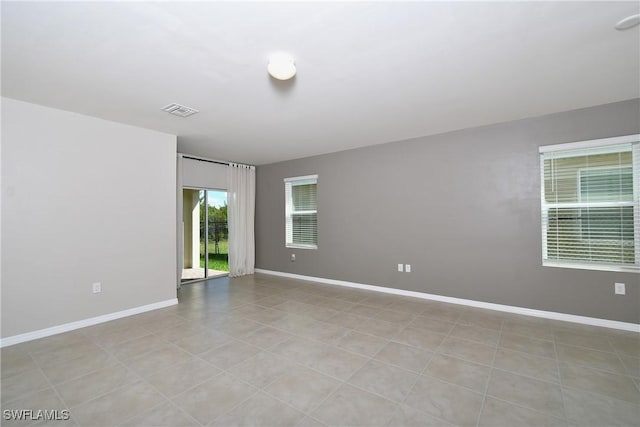 unfurnished room with baseboards and light tile patterned floors