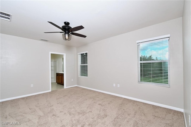 unfurnished room featuring light colored carpet, baseboards, and ceiling fan