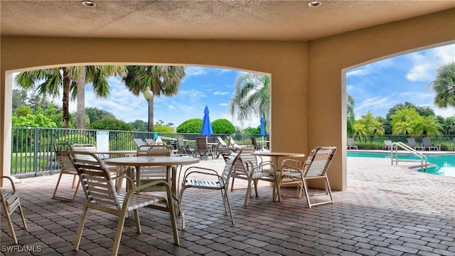 view of patio with fence and a community pool