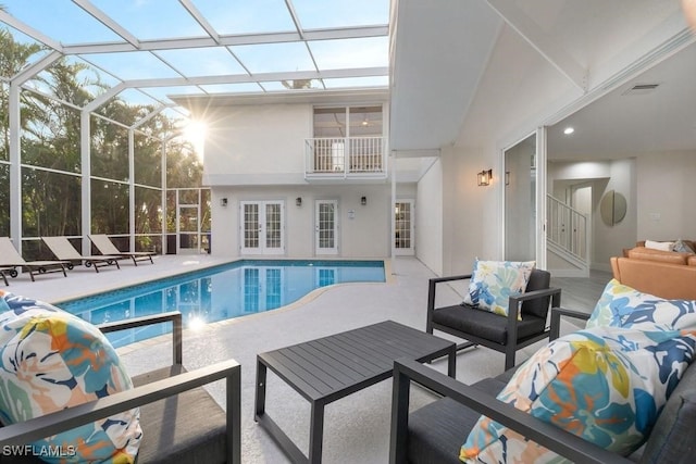 swimming pool featuring french doors, an outdoor living space, a patio area, and glass enclosure