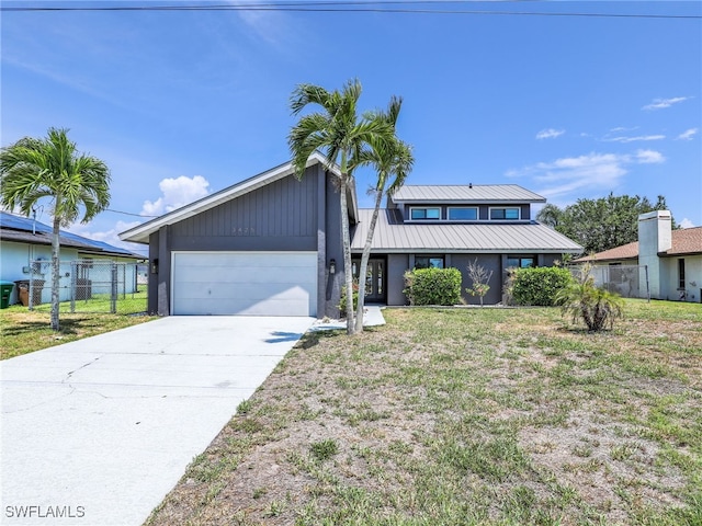 view of front of house featuring an attached garage, concrete driveway, and metal roof